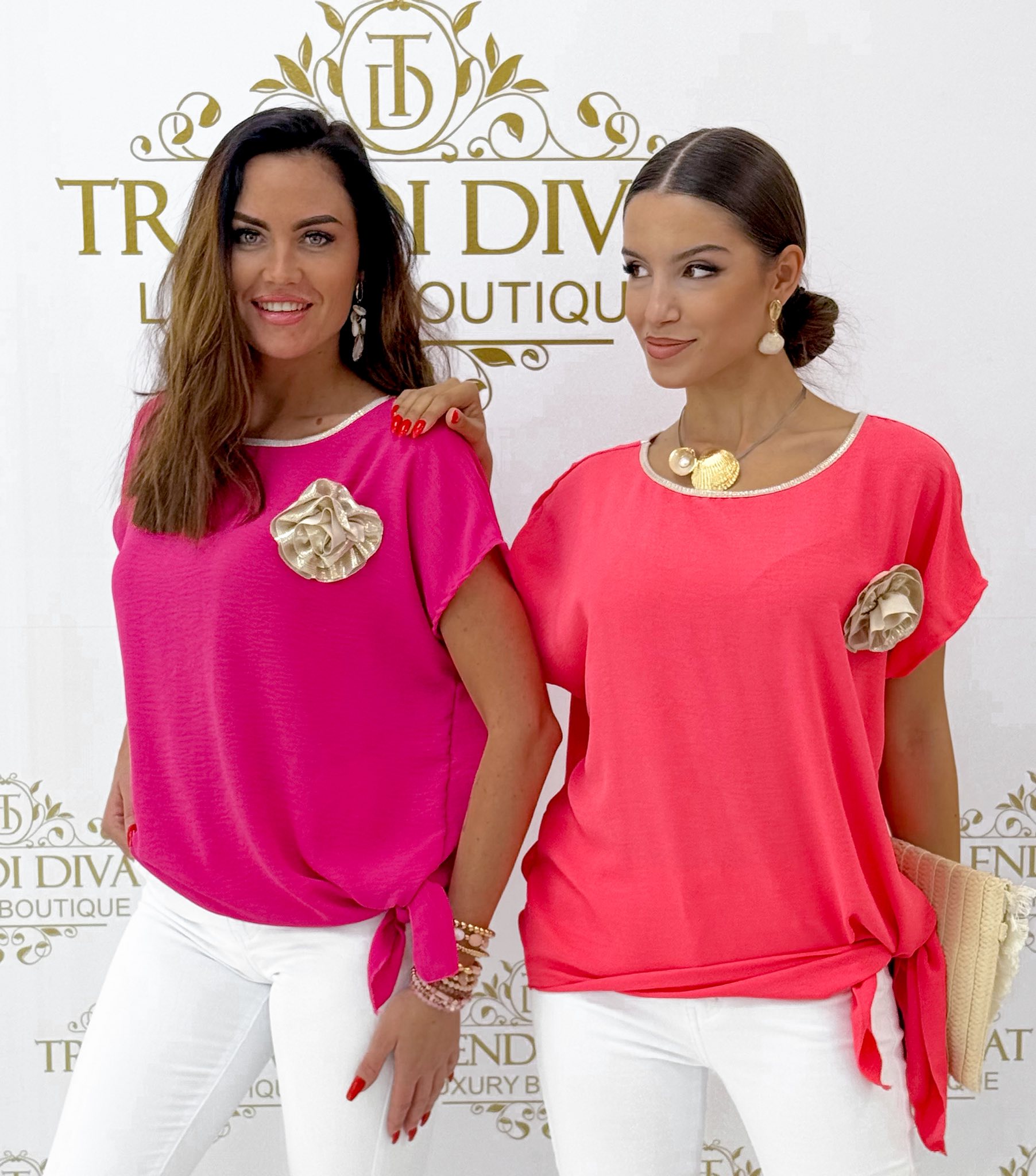 Oldalt megkötős, lenge anyagú, virágos brossal díszített felső